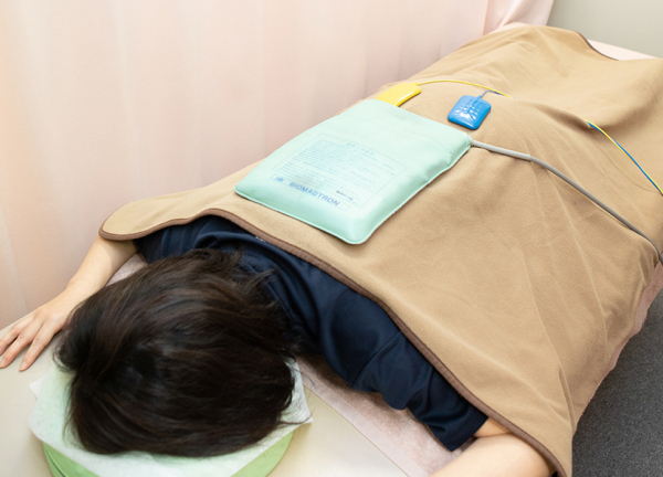 かつ神田整骨院(ホットパックを乗せて痛み箇所の循環を促進します。)