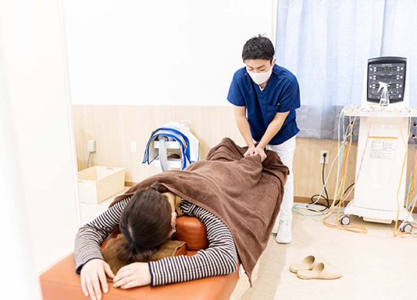 よつば整骨院(足もとを含め、細かく身体の状態を確認しながら施術をおこないます。)